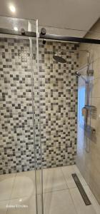 a shower with a glass door in a bathroom at Costamar Martil in Martil