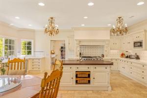 a kitchen with white cabinets and a table and chairs at @ Marbella Lane - Hidden Gem in Orange County in Orange