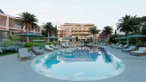 a resort with a large pool with chairs and umbrellas at Amazing vacation villa in paphos 3 Bedrooms in Khlorakas