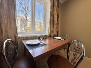 un tavolo da pranzo con sedie e una finestra di ApartPoltava Світлі та стильні апартаменти в центрі Полтави біля театру Гоголя, ЦУМ, банківський ЧЕК a Poltava Altre 11 foto