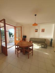 a living room with a table and a couch at VILLA MARELUNA - near the beach , family residence pet friendly ! in Capo Vaticano