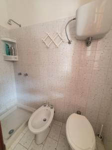a bathroom with a toilet and a bath tub at VILLA MARELUNA - near the beach , family residence pet friendly ! in Capo Vaticano +32 photos