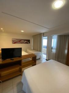 a bedroom with a bed and a flat screen tv at Mirador Praia Hotel in Natal