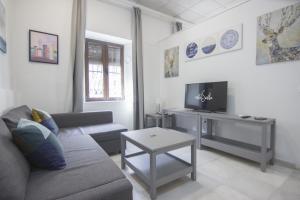 salon z kanapą i telewizorem w obiekcie RentalSevilla Cuesta del Rosario I w Sewilli