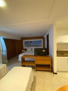 a hotel room with a bed and a desk with a laptop at Mirador Praia Hotel in Natal +6 photos