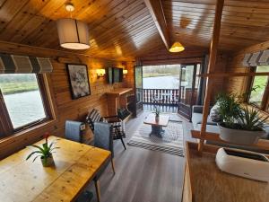 a living room and dining room of a log cabin at Ant River Lodge Houseboat in Stalham +24 photos
