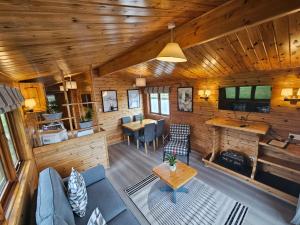 a living room and dining room of a log cabin at Ant River Lodge Houseboat in Stalham
