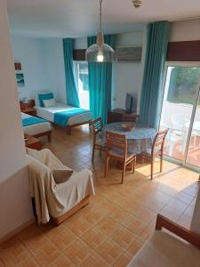 a living room with a bed and a table and chairs at Mira Parque in Albufeira