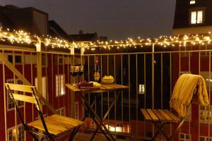 a balcony with lights and a table and chairs at Stunning 2 BR Home on Nyhavn with Private Balcony in Copenhagen