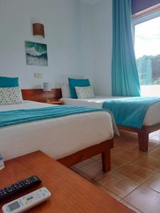 a hotel room with two beds and a remote control at Mira Parque in Albufeira +37 photos
