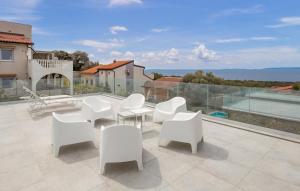a group of white chairs and tables on a patio at Charming Holiday Home with private heated pool in Jakišnica