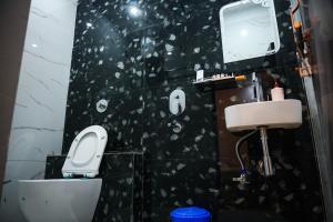 a black and white bathroom with a toilet and a sink at Sapphire By the Ganges in Prayagraj +10 photos