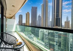 a balcony with two chairs and a view of a city at Nice 2 Bedroom Apartment! 5 Minute walk to Dubai Mall! Burj Khalifa View! in Dubai