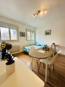 Un dormitorio con una cama y una mesa y sillas. en Le Petit Gambetta, en Charleville-Mézières