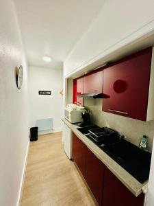 cocina con armarios rojos y encimera en Le Petit Gambetta, en Charleville-Mézières 6 fotos más