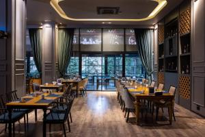 a restaurant with tables and chairs and a large window at Anemon Grand Konya Otel in Konya