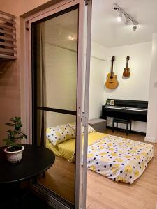 a bedroom with a bed and a piano at NestNook in Acacia Estates in Manila