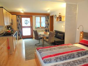 a bedroom with a bed and a kitchen with a table at Igel in Bayersoien