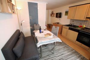 a living room with a table and a couch in a kitchen at Igel in Bayersoien