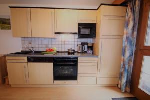 a kitchen with white cabinets and a stove top oven at Igel in Bayersoien +27 photos