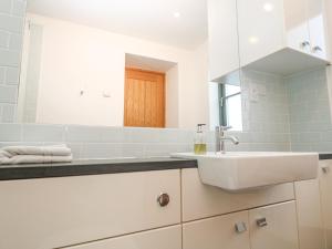 a white bathroom with a sink and a mirror at The Observatory Tower in Falmouth +33 photos