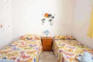 1 dormitorio con 2 camas y vestidor con mesita de noche en Costa Ballena - Apt para 6 con piscina, terraza, WiFi y parking gratis, en Rota