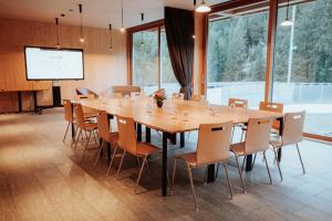 a large conference room with a large wooden table and chairs at Campra Alpine Lodge & Spa in Olivone