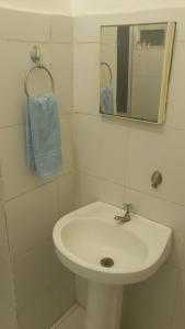 里约热内卢Apartamento temporada copacabana的一间白色浴室，配有洗手池和镜子。