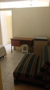 里约热内卢Apartamento temporada copacabana的客房设有书桌、床和桌子。