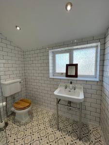 ein Badezimmer mit Toilette und Waschbecken und einem Fenster in der Unterkunft The 100 House - Llandudno in Llandudno