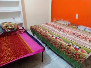 two beds sitting next to each other in a room at Ganga Homestay in Prayagraj +2 photos