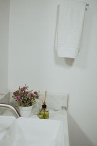 a bathroom sink with flowers on a counter at Hotel Dona Pina in Francisco Beltrão +78 photos