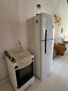 a kitchen with a white refrigerator and a stove at Pousada Styllos Maragogi in Maragogi