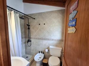 a bathroom with a white toilet and a sink at Joli Apartments - Studio 12 in San Martín de los Andes