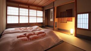a large bed in a room with windows at "NAGOMI"Kyoto Okazaki 京都岡崎の町家 和 in Kyoto