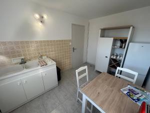 a kitchen with a table and a sink and a table and chairs at Appartment Jumapi in Fontaine-le-Comte