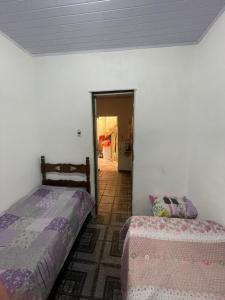 ein Schlafzimmer mit zwei Betten und ein Flur mit einer Tür in der Unterkunft Casa avenida Sílvio Felício in Diamantina