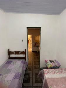 ein Schlafzimmer mit zwei Betten und ein Flur mit einer Tür in der Unterkunft Casa avenida Sílvio Felício in Diamantina