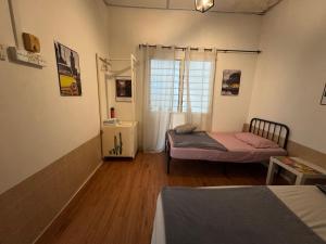 a room with two beds and a window in it at Wi-Fi 100MB free Ipoh Town Holiday House Tmn Shatin S36 in Ipoh