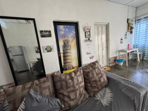 a living room with a couch and a large mirror at Wi-Fi 100MB free Ipoh Town Holiday House Tmn Shatin S36 in Ipoh