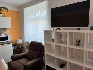 a living room with a television on a white book shelf at 18 oaks Private Countryside-palace apartment INDIA in Bauska