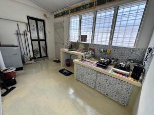 a kitchen with a counter and some windows at Wi-Fi 100MB free Ipoh Town Holiday House Tmn Shatin S36 in Ipoh