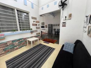 a living room with a couch and a table at Wi-Fi 100MB free Ipoh Town Holiday House Tmn Shatin S36 in Ipoh