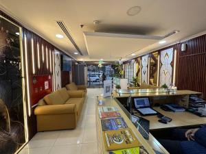 a lobby with a couch and a desk with a laptop at Aygro Hotel in Dubai