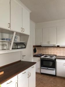 a kitchen with white cabinets and a stove at Holiday Home Bispgården in Bispgården +23 photos