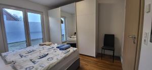 a bedroom with a bed and a mirror and a chair at Ferienhaus Luisa 2 in Aurich