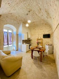 eine Küche und ein Wohnzimmer mit einem Tisch und einer Couch in der Unterkunft Rifugio Rosa in Castellana Grotte