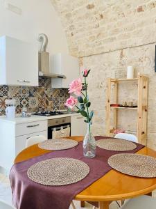 a table with three chairs and a vase with flowers at Rifugio Rosa in Castellana Grotte +14 photos