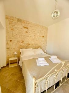 a bedroom with a bed and a brick wall at Rifugio Rosa in Castellana Grotte