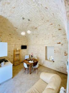 ein Wohnzimmer mit einem Tisch und einem Sofa in der Unterkunft Rifugio Rosa in Castellana Grotte + 14 Fotos
